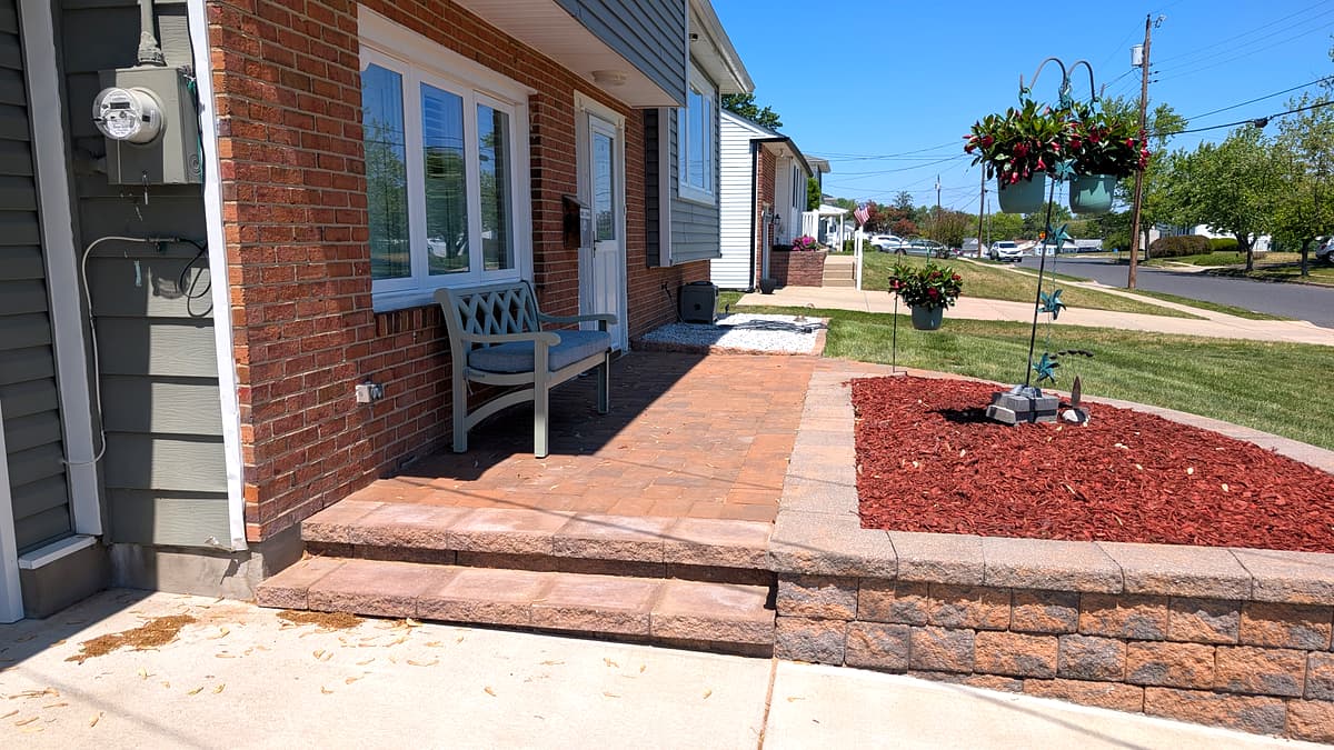 After: wider view of the finished front-entry paver steps and retaining wall